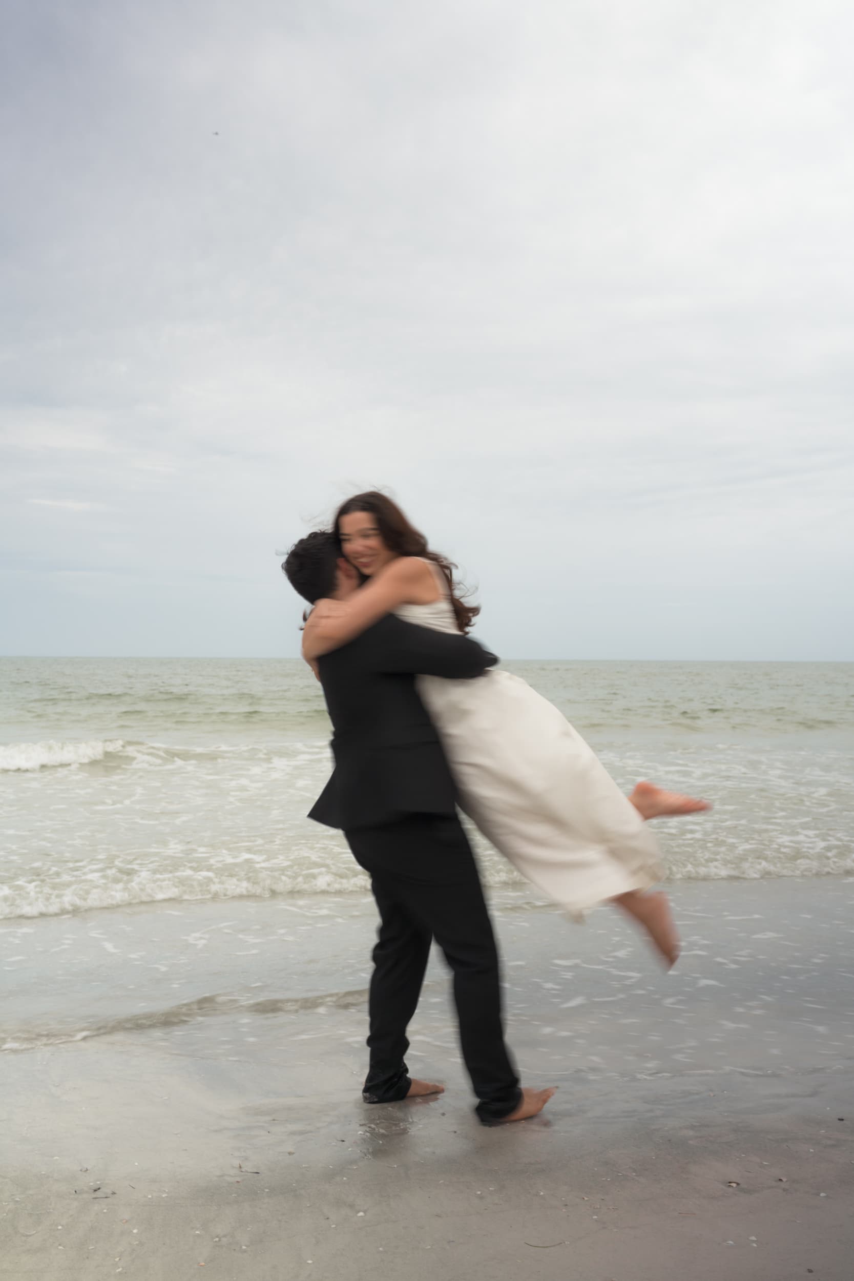 Grace and Jon Paul embracing on the beach